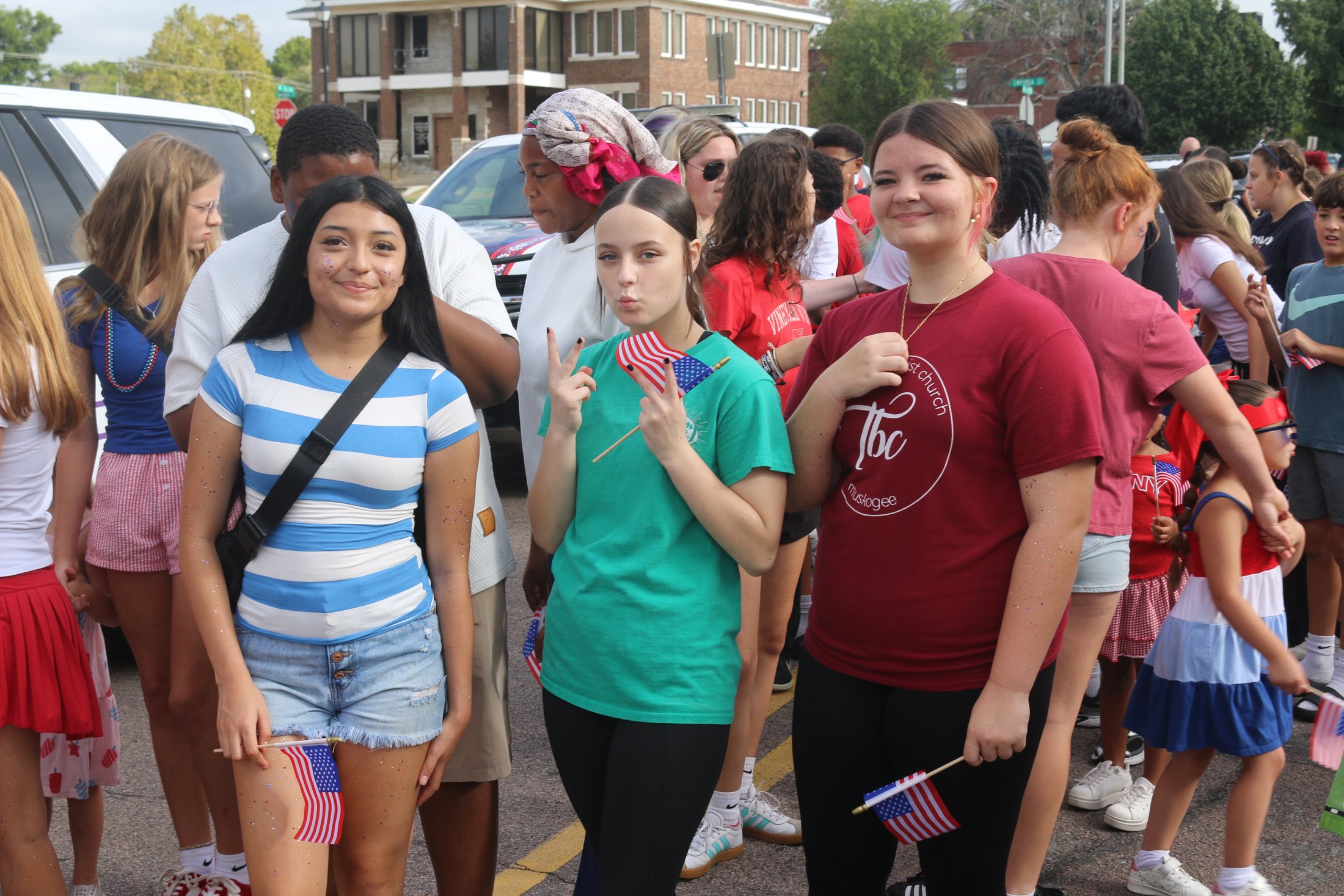Three teenage girls with American flags and glitter face paint at the Patriotic Parade